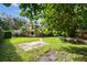 Lush backyard featuring mature trees, manicured lawn, and brick pathway at 3308 Landing Pl, Palm Harbor, FL 34684