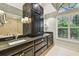 Bathroom featuring granite counters, dual sinks, and dark wood cabinets at 3308 Landing Pl, Palm Harbor, FL 34684