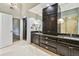 Bathroom featuring granite counters, dual sinks, and dark wood cabinets at 3308 Landing Pl, Palm Harbor, FL 34684