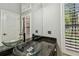 Well-lit bathroom vanity with double vessel sinks, granite countertop, and view of the green outdoors at 3308 Landing Pl, Palm Harbor, FL 34684