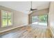 Spacious bedroom with wood floors, fan, and large window overlooking the yard at 3308 Landing Pl, Palm Harbor, FL 34684
