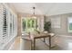 Bright dining room with shuttered windows, modern lighting and a wooden table set for six at 3308 Landing Pl, Palm Harbor, FL 34684