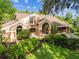 Beautiful exterior elevation showing lush tropical front yard landscaping at 3308 Landing Pl, Palm Harbor, FL 34684