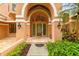 Elegant front entrance with arched doorway, modern lighting, and lush landscaping at 3308 Landing Pl, Palm Harbor, FL 34684