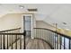 Bright hallway with elegant wood flooring and black railing, creating a warm and inviting transition at 3308 Landing Pl, Palm Harbor, FL 34684