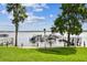 Picturesque lakefront view featuring private boat docks and lush green lawn at 3308 Landing Pl, Palm Harbor, FL 34684