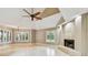 Open floor plan with fireplace, travertine floors, and plantation shutters, seamlessly connecting living spaces at 3308 Landing Pl, Palm Harbor, FL 34684