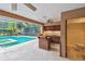 Backyard featuring a swimming pool, hot tub and a tiki bar with wood cabinets at 3308 Landing Pl, Palm Harbor, FL 34684