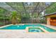Enclosed screened pool with in-ground spa, lush tropical plants, and an outdoor bar at 3308 Landing Pl, Palm Harbor, FL 34684
