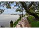 Scenic view of a lakeside boardwalk beneath mature trees, offering a peaceful walking experience at 3308 Landing Pl, Palm Harbor, FL 34684