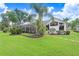 Serene backyard showcasing a lush lawn, mature trees, and a screened lanai for enjoyable outdoor gatherings at 3519 Old Course Ln, Valrico, FL 33596