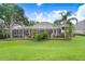Expansive backyard featuring manicured lawn, screened lanai, and lush tropical landscaping for tranquil outdoor living at 3519 Old Course Ln, Valrico, FL 33596