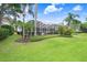 Expansive backyard featuring manicured lawn, screened lanai, and lush tropical landscaping for tranquil outdoor living at 3519 Old Course Ln, Valrico, FL 33596
