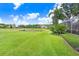 Sprawling backyard featuring a manicured lawn, mature trees, and scenic views of a tranquil pond at 3519 Old Course Ln, Valrico, FL 33596