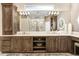 Dual sinks with cabinet storage underneath, a chandelier, and an oval mirror in bathroom at 3519 Old Course Ln, Valrico, FL 33596