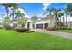 Beautiful home with lush landscaping, palm trees, and a circular brick driveway at 3519 Old Course Ln, Valrico, FL 33596