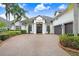 Attractive front exterior with a circular brick driveway, meticulous landscaping, and double-door entrance at 3519 Old Course Ln, Valrico, FL 33596