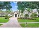 Elegant home with a circular driveway, lush landscaping, and inviting entrance at 3519 Old Course Ln, Valrico, FL 33596