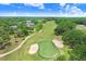 Aerial view of the lush green golf course featuring sand traps and palm trees at 3519 Old Course Ln, Valrico, FL 33596