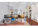 A bright office featuring custom built-ins, glass shelving, and a desk with multiple monitors at 3519 Old Course Ln, Valrico, FL 33596