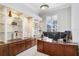 A well-appointed home office with custom built-ins, hardwood cabinets, and space for multiple monitors at 3519 Old Course Ln, Valrico, FL 33596