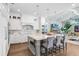 An open-concept kitchen with white cabinets, granite countertops, and an island with seating for four at 3519 Old Course Ln, Valrico, FL 33596