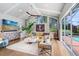Bright living room with hardwood floors, a modern ceiling fan and a sliding glass door to the backyard at 3519 Old Course Ln, Valrico, FL 33596