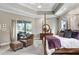 Bright main bedroom featuring tray ceilings, access to the pool, and a relaxing sitting area at 3519 Old Course Ln, Valrico, FL 33596