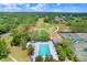 Aerial view of community pool, tennis courts, and golf course with lush green landscaping under a bright blue sky at 3519 Old Course Ln, Valrico, FL 33596