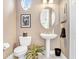Cozy powder room with pedestal sink, oval mirror, and decorative accents creating a welcoming space at 3519 Old Course Ln, Valrico, FL 33596