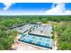 Aerial view of multiple tennis and pickleball courts, well-maintained, with lush greenery and a pond at 3519 Old Course Ln, Valrico, FL 33596
