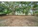 Large backyard with mature trees and partial fencing around the property at 3812 W Rogers Ave, Tampa, FL 33611