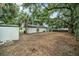 Spacious, partially fenced backyard with large shade trees and storage shed at 3812 W Rogers Ave, Tampa, FL 33611