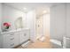 Bright bathroom with a glass-enclosed shower, modern vanity, and stylish round mirror at 3812 W Rogers Ave, Tampa, FL 33611