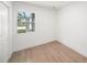 Bright bedroom featuring sleek wood floors and a window showcasing the outdoor view at 3812 W Rogers Ave, Tampa, FL 33611