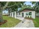 Charming single-story home with white exterior, stylish landscaping and a welcoming pergola-covered entry at 3812 W Rogers Ave, Tampa, FL 33611