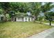 Charming front yard featuring mature shade trees, lush green lawn, and a long driveway at 3812 W Rogers Ave, Tampa, FL 33611