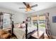 Cozy bedroom with a dark wood bed, patterned curtains, and a vintage ceiling fan at 4012 N Munro St, Tampa, FL 33603