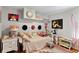 Stylish bedroom featuring unique decor, including wall art, decorative hats, and a vintage-style bed at 4012 N Munro St, Tampa, FL 33603