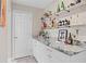 Charming butler pantry featuring granite countertop and white cabinets with shelves holding glassware and spirits at 4012 N Munro St, Tampa, FL 33603