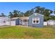 View of the blue home showcasing the attached garage, fenced yard, and proximity to neighboring houses at 4012 N Munro St, Tampa, FL 33603