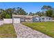 Charming blue home featuring an attached garage, a welcoming front porch, and a beautifully paved driveway at 4012 N Munro St, Tampa, FL 33603