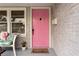 A vibrant pink front door enhances the home's curb appeal and leads into a cozy and inviting space at 4012 N Munro St, Tampa, FL 33603