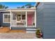 Close-up of the blue home's front porch highlighting its white railing and vibrant pink front door at 4012 N Munro St, Tampa, FL 33603