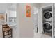 Hallway featuring a stackable washer and dryer, with granite counter and stainless steel appliances nearby at 4012 N Munro St, Tampa, FL 33603