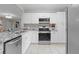 Bright kitchen showcasing white cabinets, granite countertops, stainless steel appliances, and tile flooring at 4012 N Munro St, Tampa, FL 33603