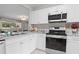Modern kitchen featuring stainless steel appliances, granite countertops, and white cabinets with tile flooring at 4012 N Munro St, Tampa, FL 33603