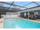 A large screened-in pool features patio seating, mature landscaping, and a white fence at 4012 N Munro St, Tampa, FL 33603
