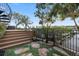 Backyard with stone pathway, wood deck, metal railing, garden area, and lush greenery at 4128 Causeway Vista Dr, Tampa, FL 33615