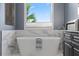 Freestanding bathtub with marble surround and window view at 4128 Causeway Vista Dr, Tampa, FL 33615